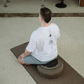 Person sitzt auf dem ShaktiMat Meditationskissen Granitschwarz