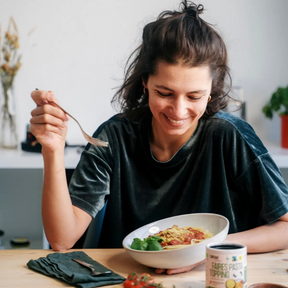 Person ist Nudeln mit Pasta Topping und freut sich